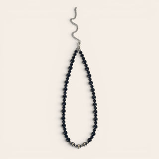 Black beaded necklace on a light gray background