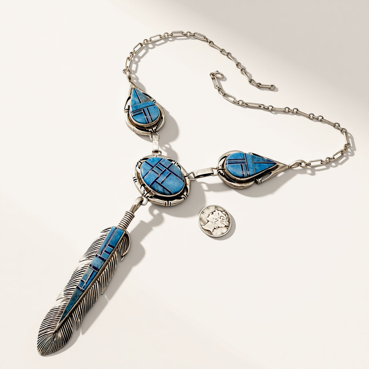 Silver necklace with blue stone pendants on a white background