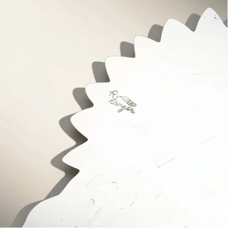close up of silver jewelry on a beige background.