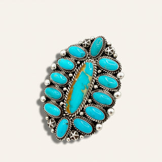 Turquoise stone ring with silver detailing on a white background