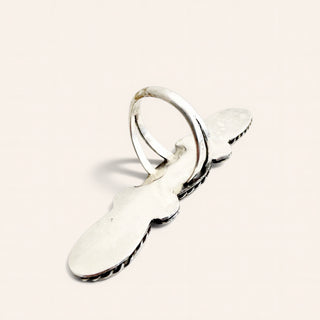 A sterling silver ring with a textured, hammered finish on a warm off-white background.