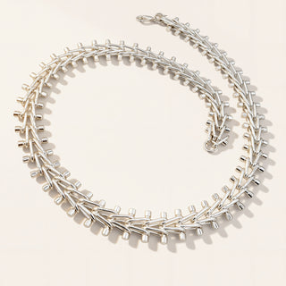 Silver necklace on a light beige background