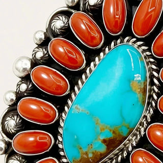 Jewelry with turquoise stone and red stones on a gray background
