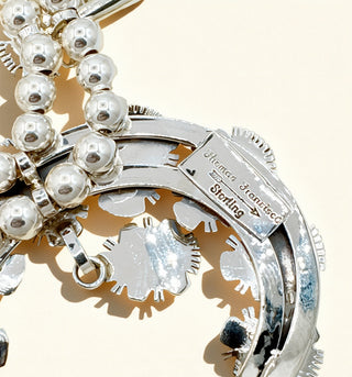 Silver naja with pearls and 'Thomas Francisco' branding on a white background