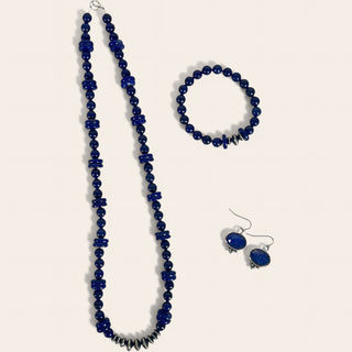 Set of blue beaded necklace, bracelet, and earrings on a white background
