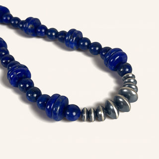 Necklace with blue beads and silver accents on a white background