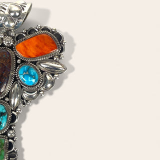 Close-up of a silver jewelry with colorful stones on a light gray background