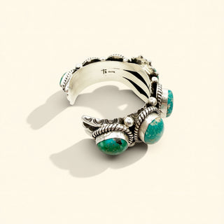 Silver cuff with turquoise stones on a white background