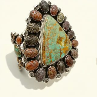 Turquoise and brown stone ring with silver accents on a white background