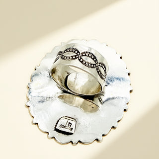 Silver ring shank against a beige background