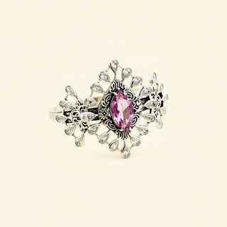 Silver cuff with a pink stone on a beige background