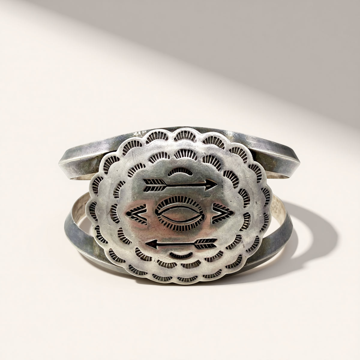 Silver bracelet with intricate designs on a white background