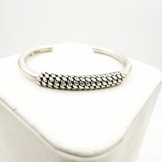 Silver bangle on a white surface
