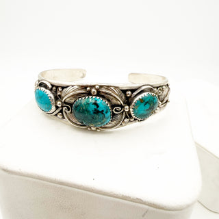 Silver bracelet with turquoise stones on a white background