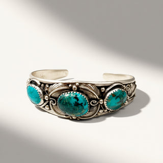 Silver bracelet with turquoise stones on a gray background