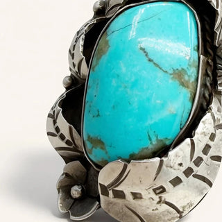 Silver ring with a large turquoise stone on a white background