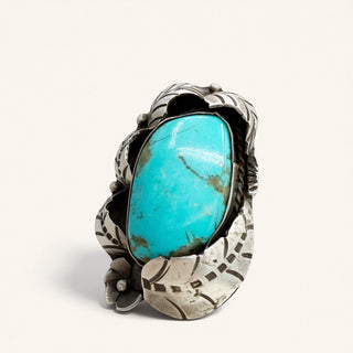 Silver ring with a large turquoise stone on a white background