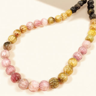 Necklace with pink, brown, and black beads on a beige background