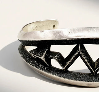 Silver bracelet with geometric design on a gray background