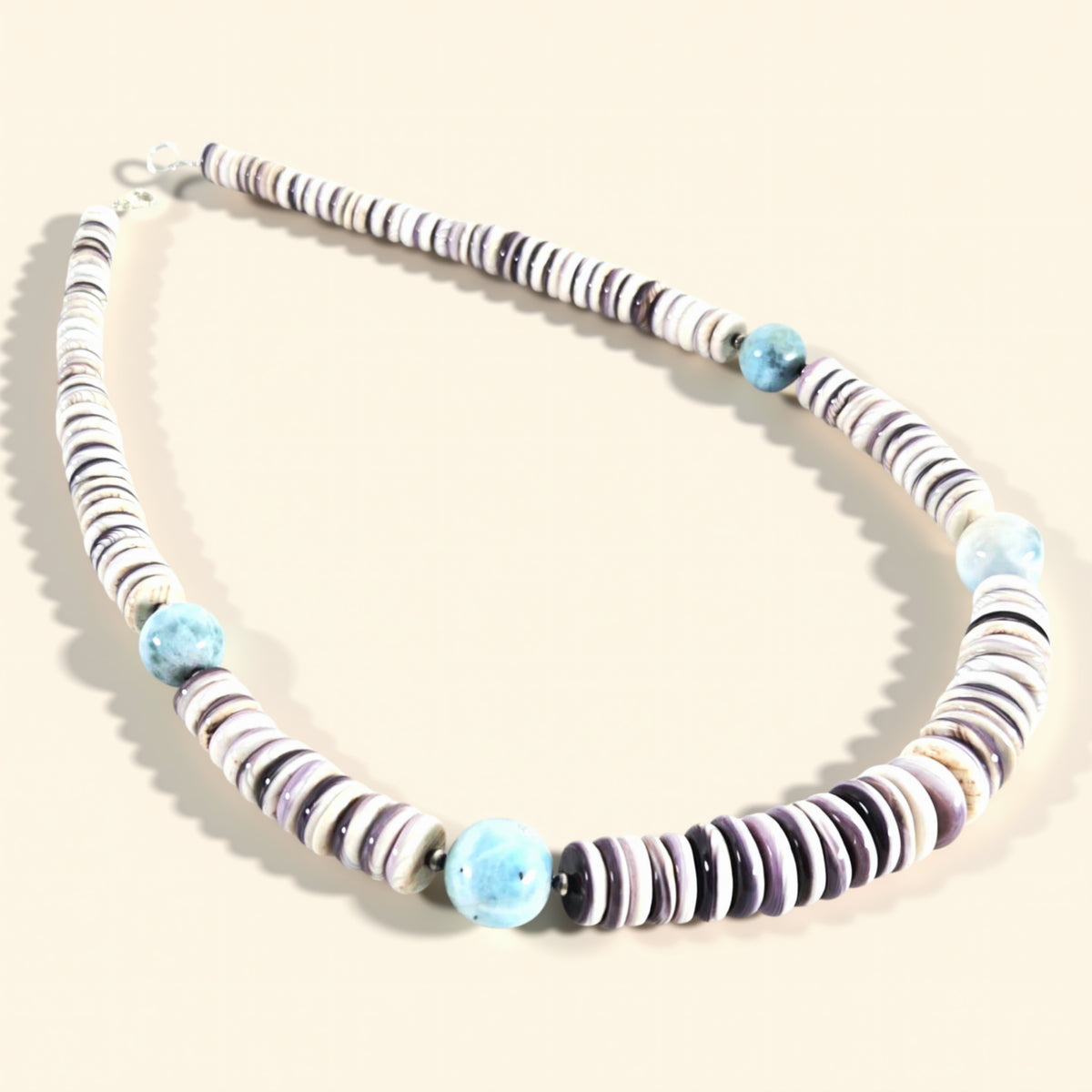 Necklace with striped beads on a beige background