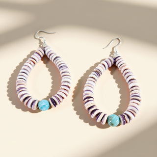 Hoop earrings with multicolored beads on a beige background