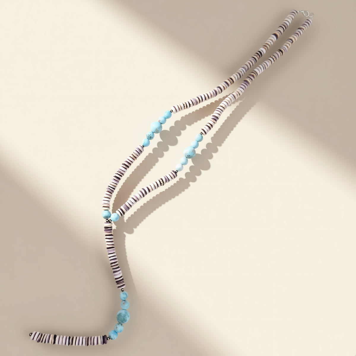 Necklace with blue and multicolored beads on a beige background