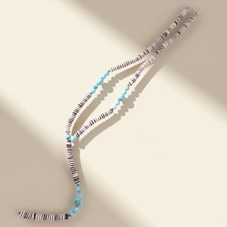 Necklace with blue and multicolored beads on a beige background