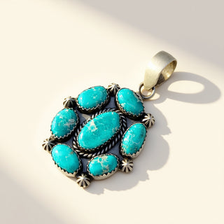 Turquoise pendant with silver setting on a light background