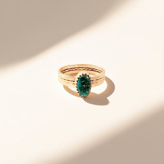 Ring with a green gemstone on a beige background