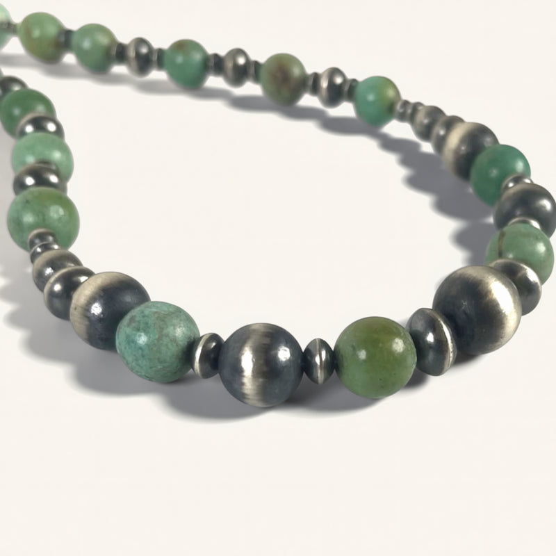 Necklace with green and silver beads on a white background